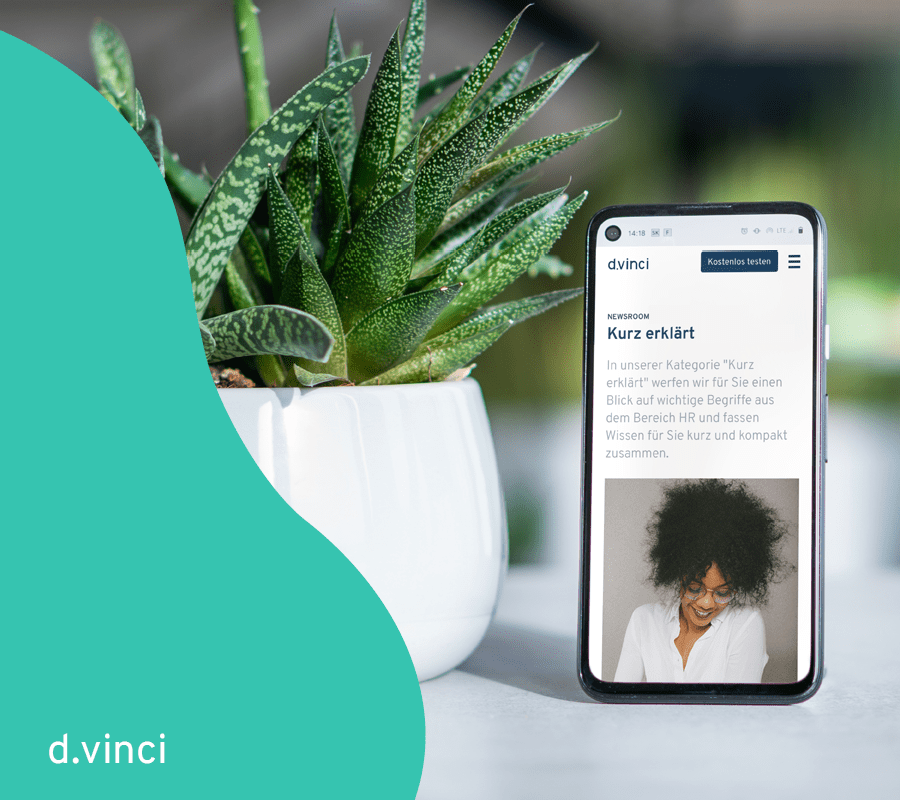 Ein Foto zeigt ein Handy neben einer Topfpflanze. Auf dem Handy ist der Beginn eines Artikels im d.vinci Newsroom zu sehen. Geschmückt ist das Bild mit einer türkisen Welle von links.