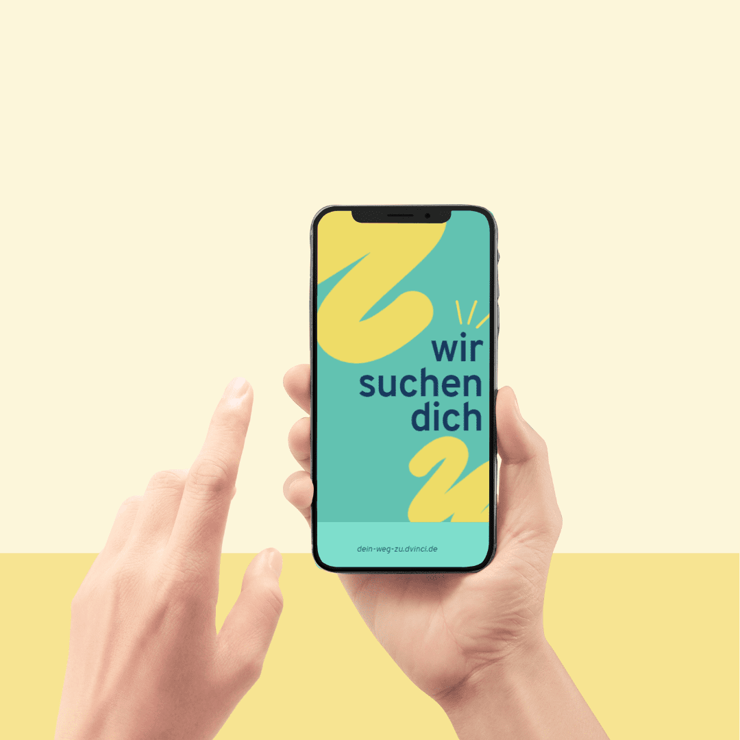 Eine Grafik zeigt ein Smartphone in den Händen einer Person vor einem gelben Hintergrund. Auf dem Smartphone ist ein türkises Bild mit dem Text "Wir suchen dich" abgebildet.